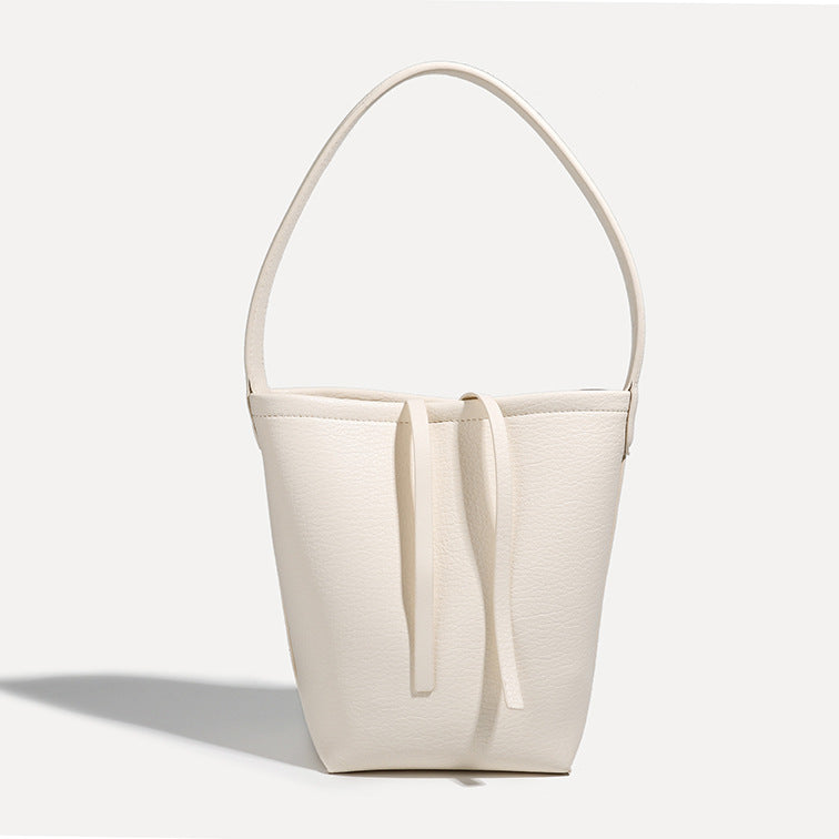 Mini tapered bucket bag in pebbled leather-look finish with front tie straps and single shoulder strap, detail view 7