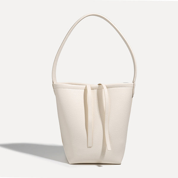 Mini tapered bucket bag in pebbled leather-look finish with front tie straps and single shoulder strap, detail view 7