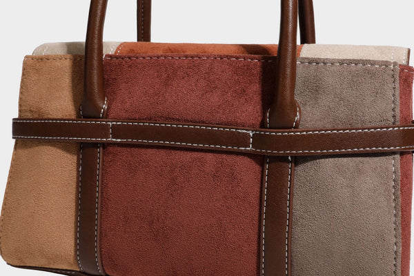 Structured color-block satchel bag in brown, rust, beige, and taupe suede-look panels with white topstitching, front buckle