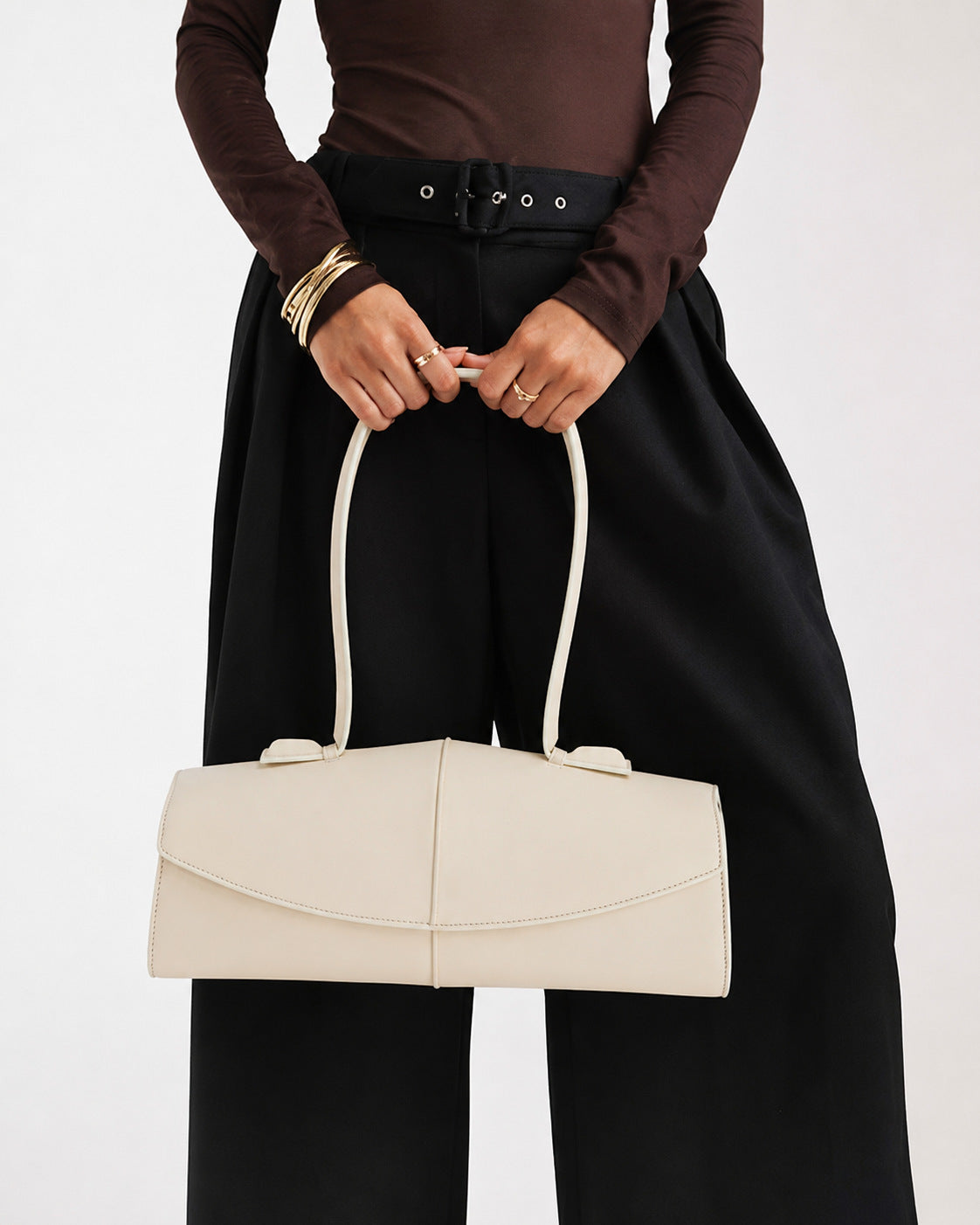 Elongated structured baguette shoulder bag with curved flap closure and slim looped strap, detail view 10