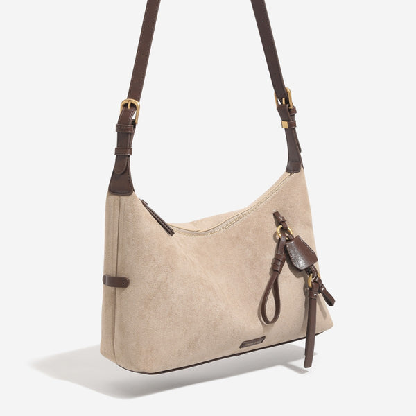 Hobo-Schultertasche in Sand mit Velourslederoptik, dunkelbraunen Riemen aus Lederimitat, goldfarbenen Metalldetails, Reißverschluss oben und hängendem