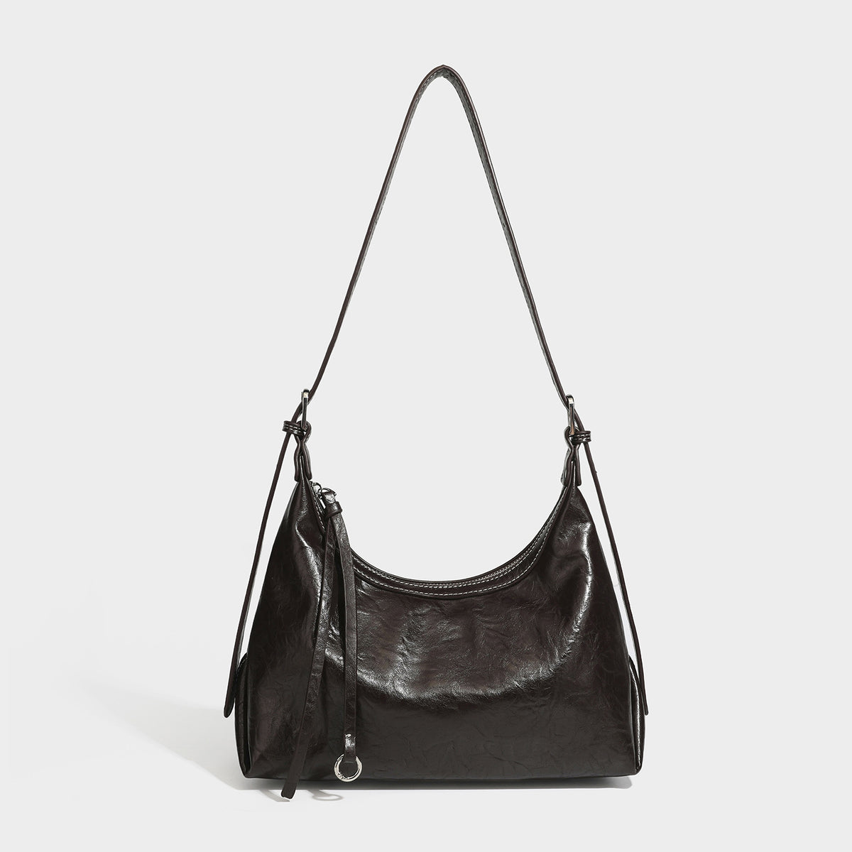 Slouchy hobo shoulder bag in glossy crinkled leather-look finish with zip-top closure and silver-tone ring hardware, detail