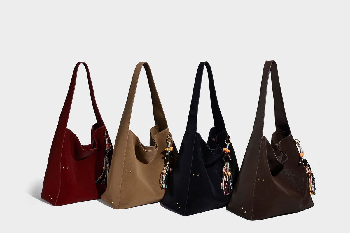 Oversized trapezoid tote bag with matte leather-look finish, gold-tone rivets, and long shoulder strap, detail view 10