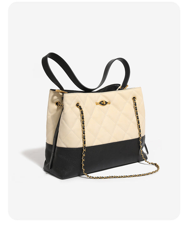 Large quilted two-tone shoulder tote bag with gold-tone chain handles and eye-shaped clasp hardware, detail view 8