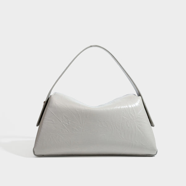Glänzende, geknautschte Trapez-Schultertasche mit Überschlagverschluss, goldfarbenen Logo-Beschlägen, Tragegriff und abnehmbarem, verstellbarem Schulterriemen