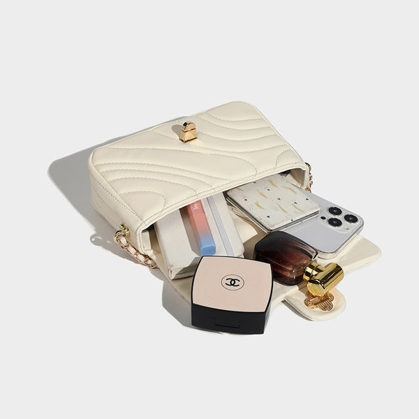 Compact cream quilted flap crossbody bag with wave stitching, gold-tone chain strap, and four-petal turn-lock clasp, detail
