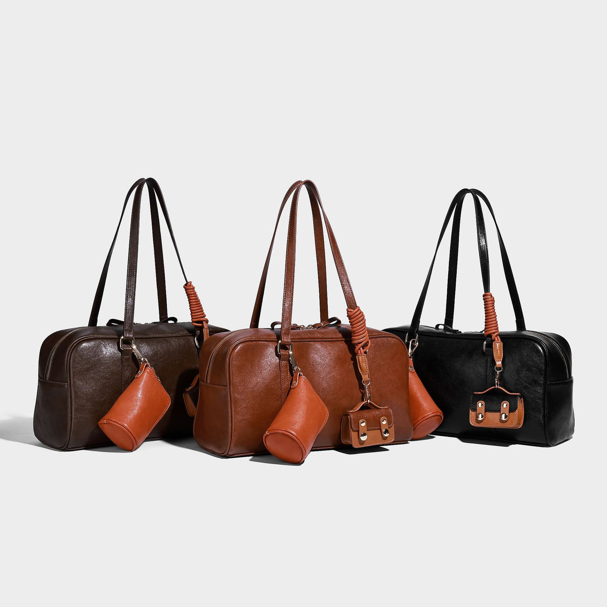 Strukturierte Boston-Schultertasche in glänzender Lederoptik mit zwei langen Trageriemen, Reißverschluss oben, goldfarbenen Metalldetails und zwei