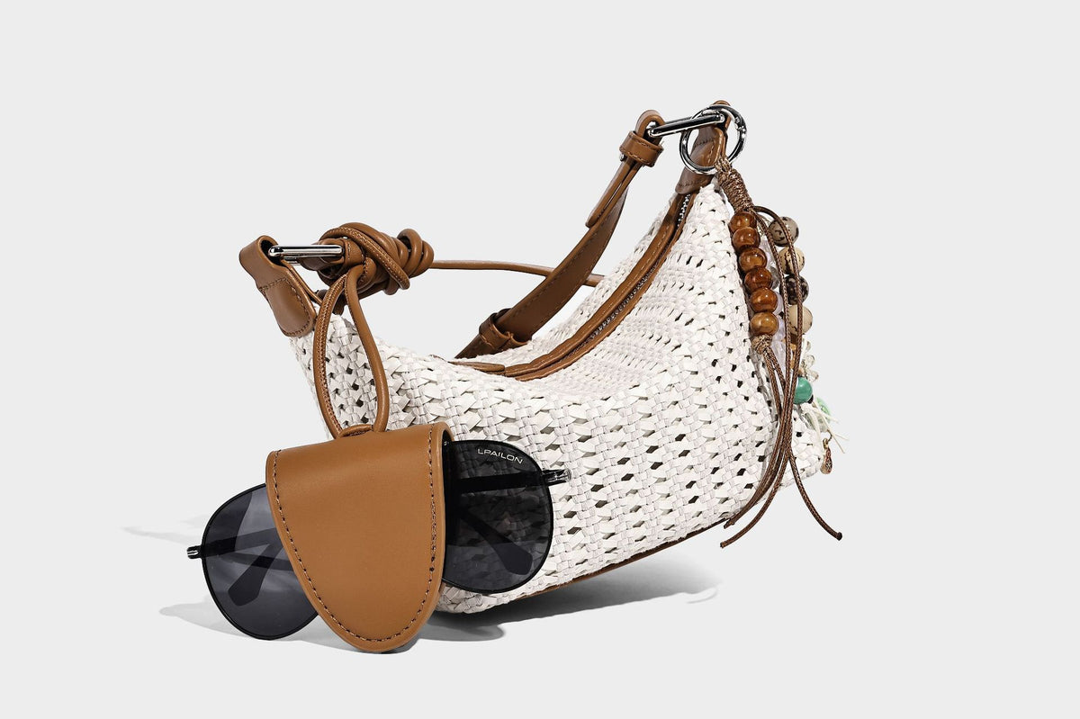 Woven crescent shoulder bag with leather-look knotted handle, zip top, attached mini pouch, and silver-tone hardware, detail