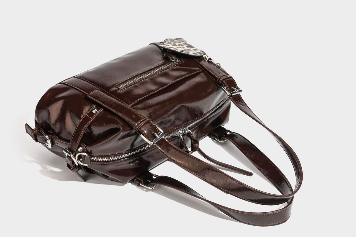 Strukturierte Schultertasche in glänzender Lederoptik mit abgerundetem Korpus, silberfarbenen Beschlägen, Reißverschlussfach auf der Vorderseite und Leopardenmuster