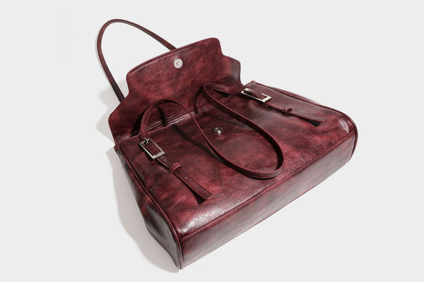 Structured flap-top shoulder tote bag in distressed leather-look finish with silver-tone buckle hardware and double shoulder