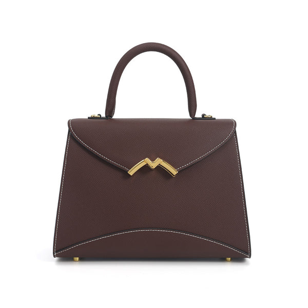Structured trapezoid top-handle satchel in golden brown cross-grain textured finish with gold M-shaped clasp hardware and