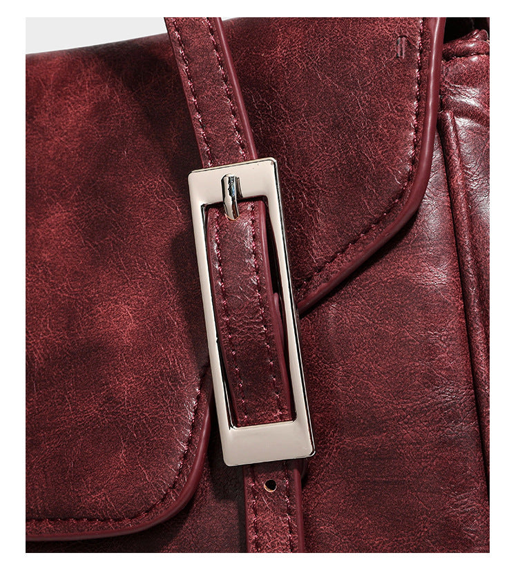 Structured flap-top shoulder tote bag in distressed leather-look finish with silver-tone buckle hardware and double shoulder