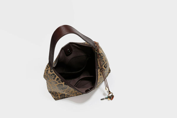 Lässige Hobo-Shopper-Tasche mit Leopardenmuster in Tan und Braun, dunkelbraunem Riemen in Lederoptik und herabhängendem Perlenanhänger an den Beschlägen