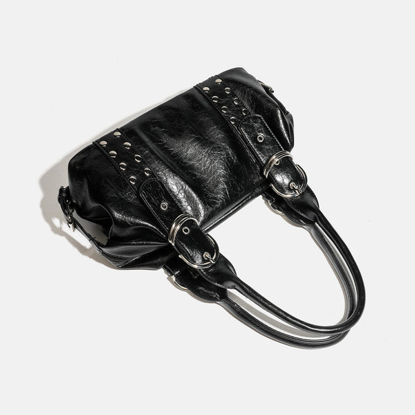 Compact black glossy leather-look satchel bag with silver-tone rivets, buckle hardware, and dual padded top handles, detail