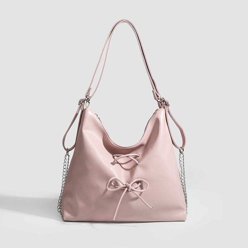 Glossy leather-look hobo shoulder bag with front bow lacing detail and silver-tone chain strap, front view