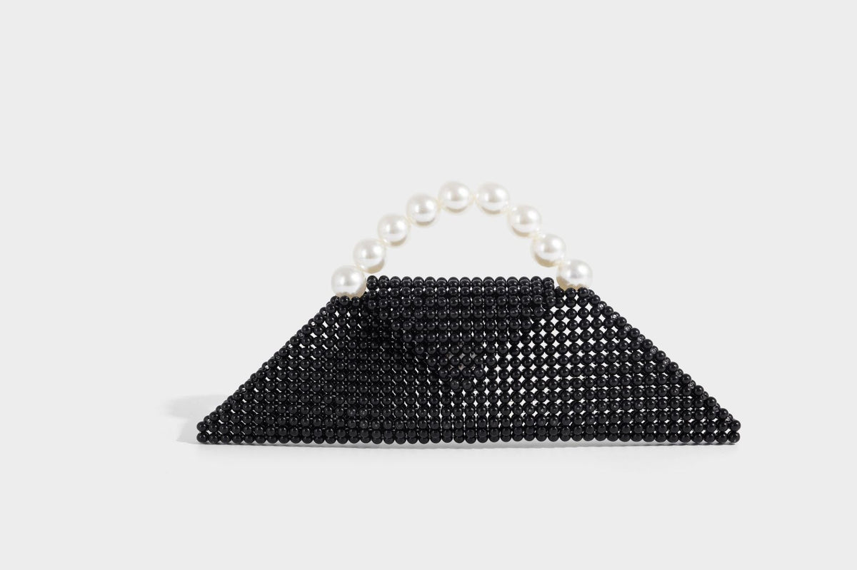 Small structured triangle clutch bag covered in glossy pearl beads with an arched pearl top handle and silver snap closure