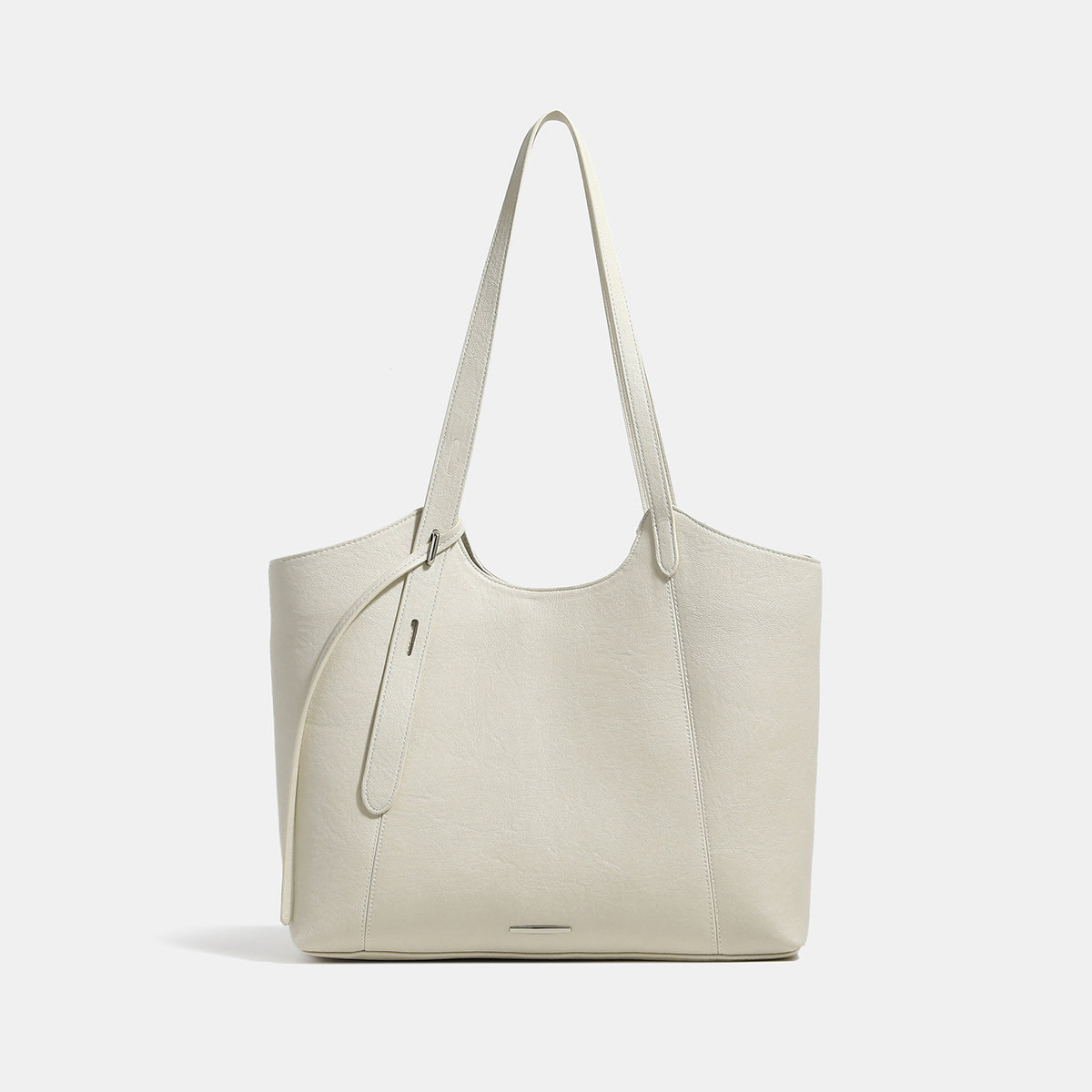 Structured trapezoidal tote bag with smooth leather-look finish, long black contrast shoulder straps, and dangling strap