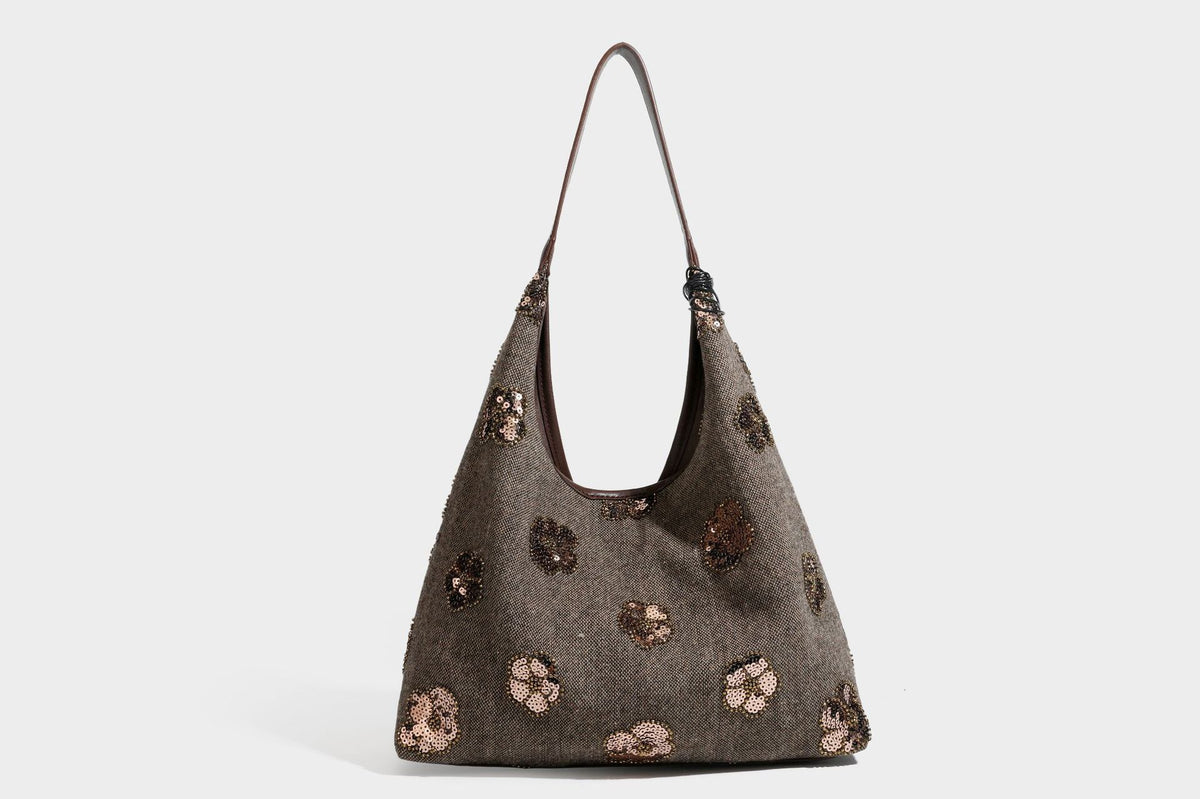 Weich fallende, trapezförmige Schultertasche in Anthrazitgrau mit floralen Motiven aus silbernen Pailletten, Riemen in Lederoptik und herabhängenden Perlen