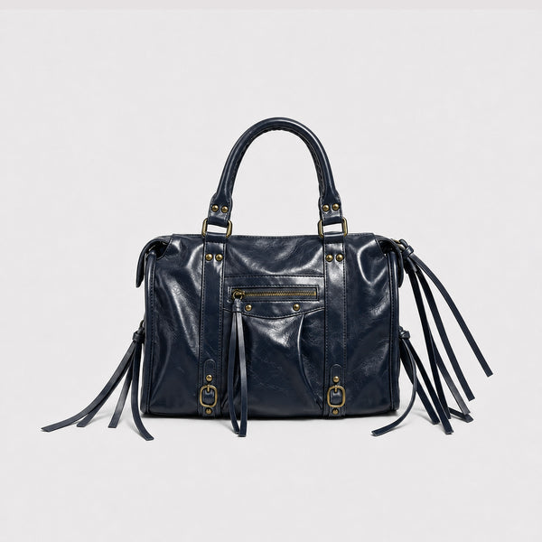 Structured glossy leather-look satchel bag with brass-tone studs, side tassel fringe, dual top handles, and front zip pocket