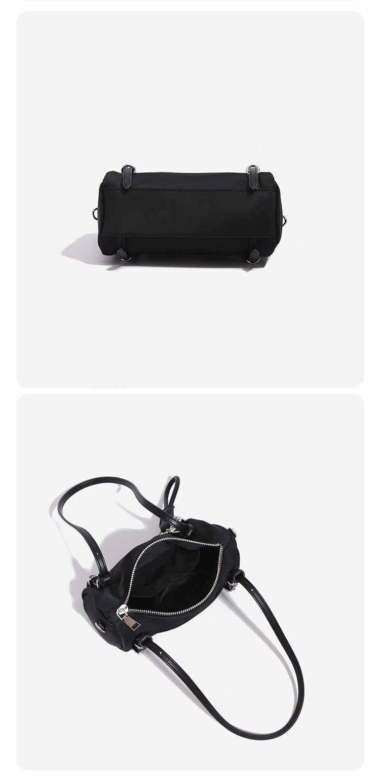 Compact nylon Boston barrel bag with zip-top closure, silver-tone hardware, dual slim handles, and detachable crossbody
