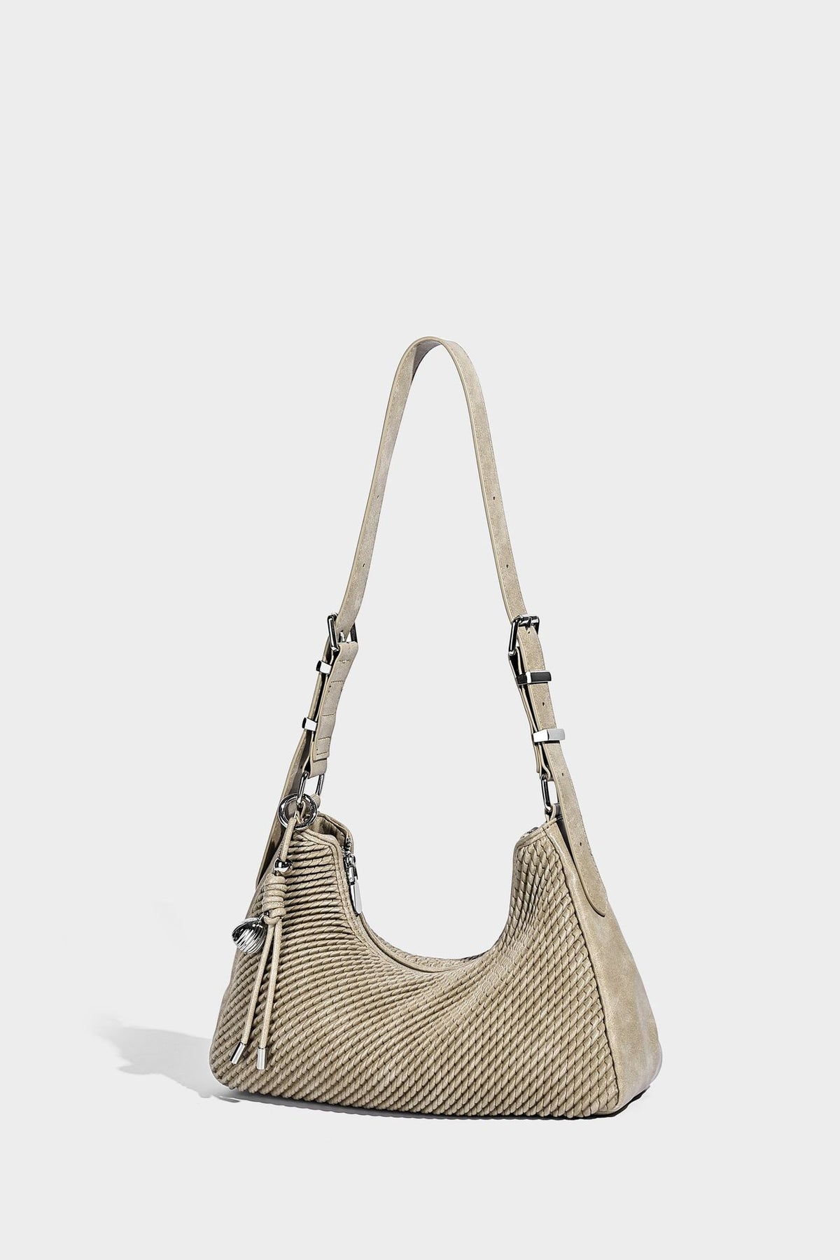 Woven crescent hobo shoulder bag with smooth side panels, zip-top closure, silver-tone charm hardware, and adjustable, detail