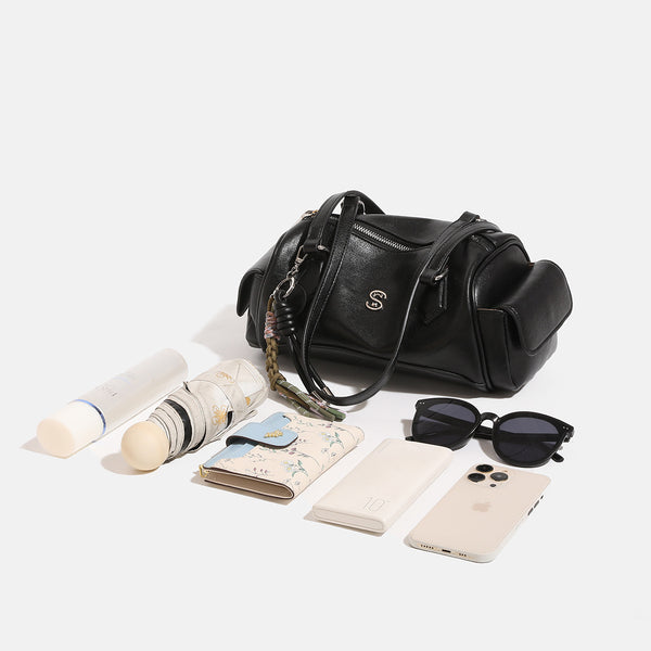Schwarze Barrel-Schultertasche in Lederoptik mit silberfarbenen Reißverschlussbeschlägen, zwei flachen Tragegriffen, seitlicher Klappentasche und gewebtem Oliv