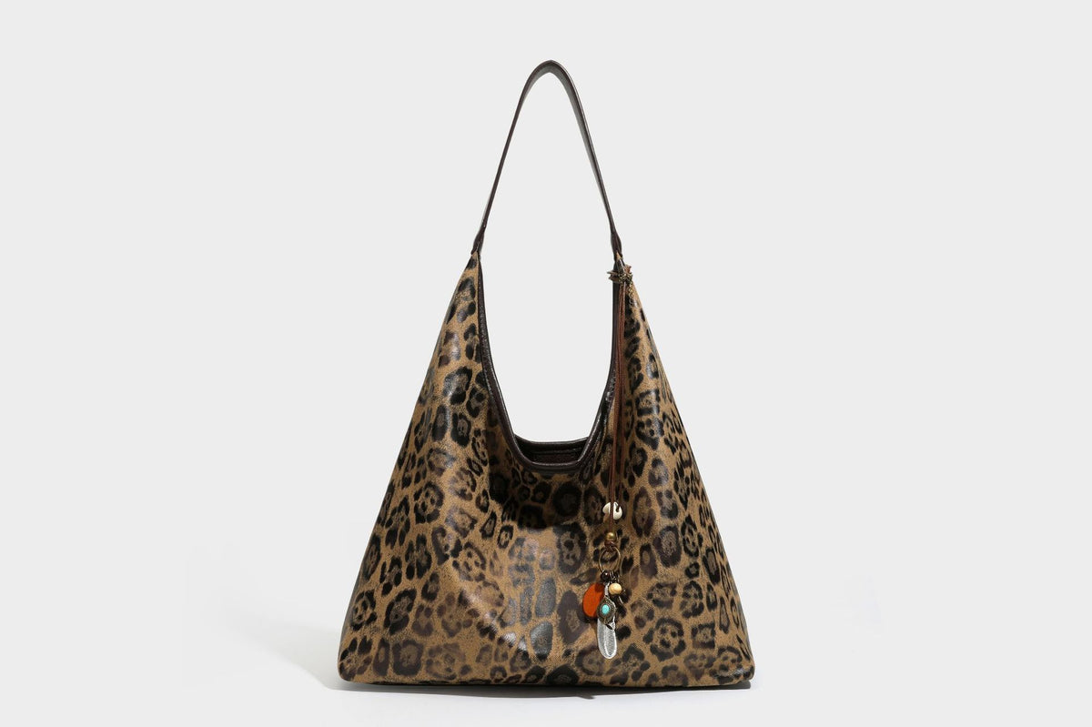 Weich fallende Hobo-Tote-Bag mit Leopardenmuster in Beige und Braun, dunkelbraunem Riemen in Lederoptik und herabhängenden Perlenanhänger-Beschlägen