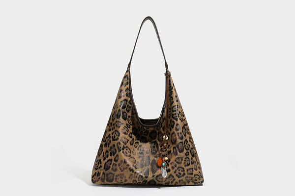 Weich fallende Hobo-Tote-Bag mit Leopardenmuster in Beige und Braun, dunkelbraunem Riemen in Lederoptik und herabhängenden Perlenanhänger-Beschlägen