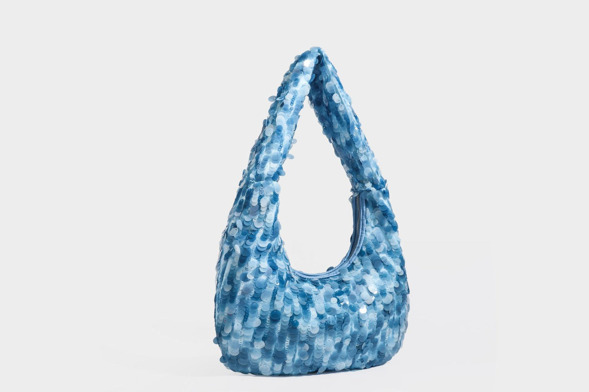 Slouchy crescent hobo shoulder bag covered in overlapping reflective sequin discs with a single integrated strap and top-zip
