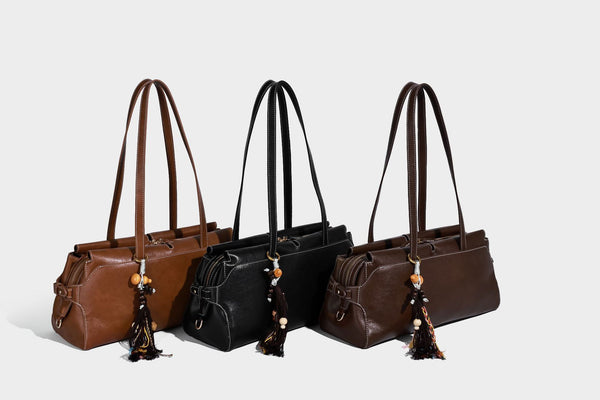 Strukturierte rechteckige Baguette-Schultertasche aus dunkelbraunem Material in glatter Lederoptik mit zwei Riemen und Reißverschluss oben