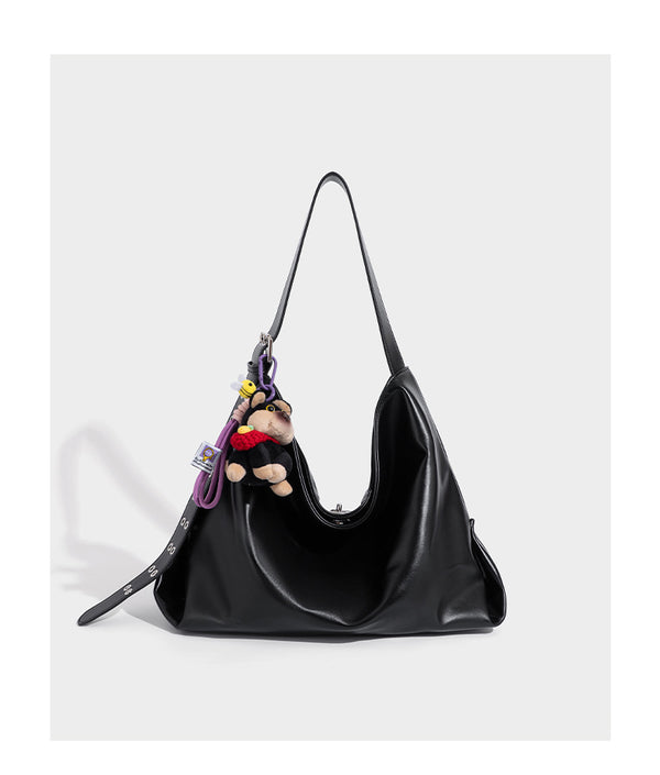 Große schwarze, weich fallende Hobo-Schultertasche in glänzender Lederoptik mit mit Ösen besetztem Riemen, silberfarbenen Metallbeschlägen und abnehmbarem