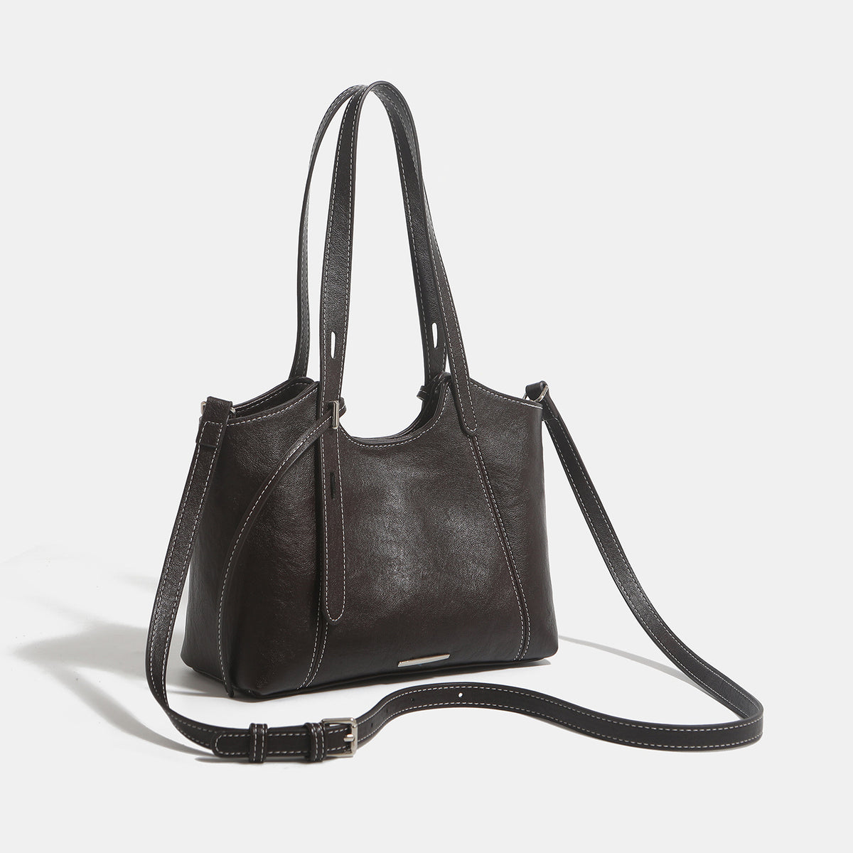 Structured leather-look tote shoulder bag with double crossed straps, contrast topstitching, and metal bar hardware, detail