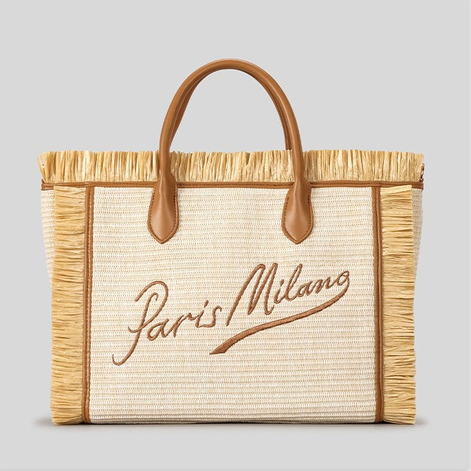 Natural ivory woven straw tote bag with raffia fringe trim, cognac leather-look handles, Paris Milano embroidered script