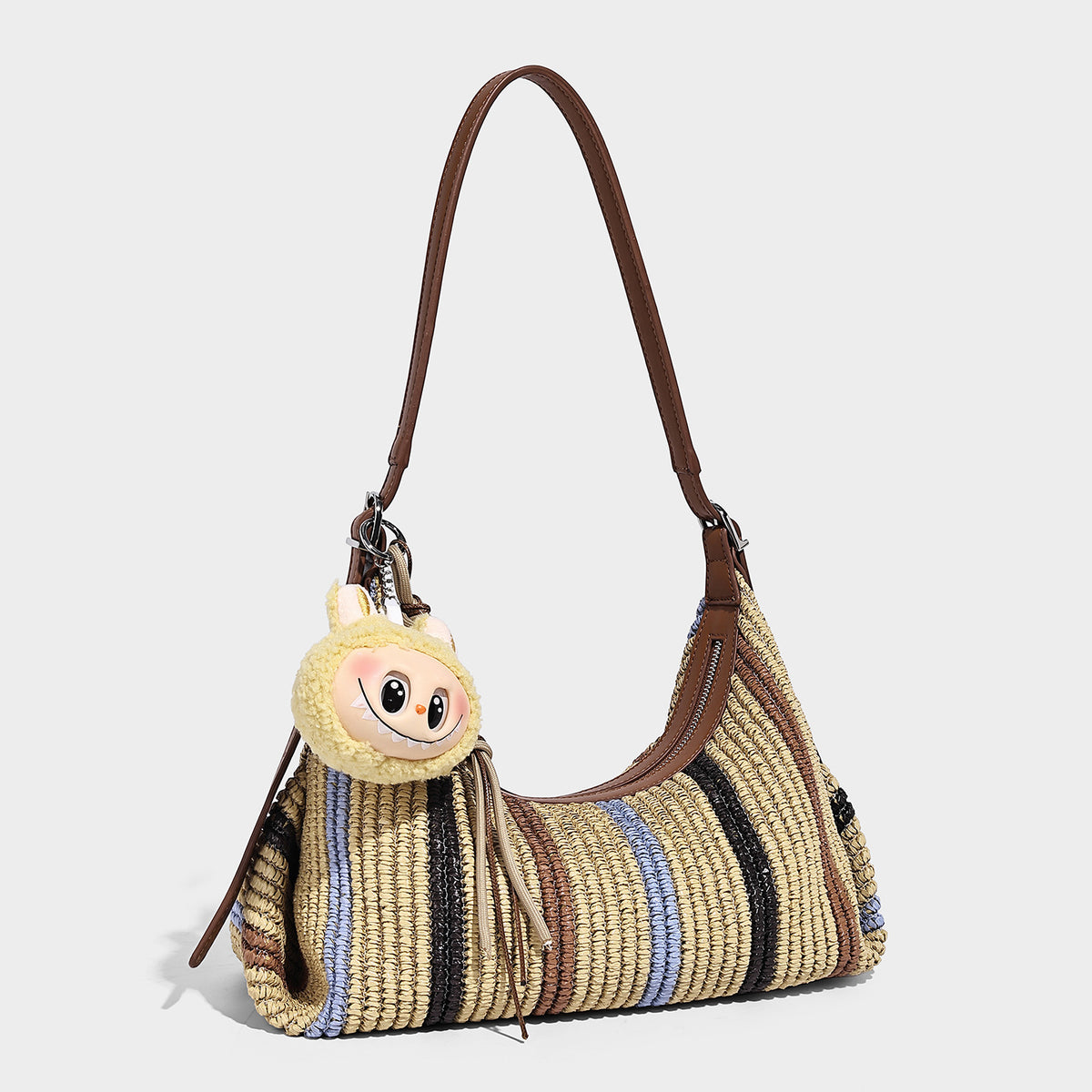 Slouchy woven straw hobo shoulder bag with beige, black, brown, and blue vertical stripes and brown leather-look trim, detail
