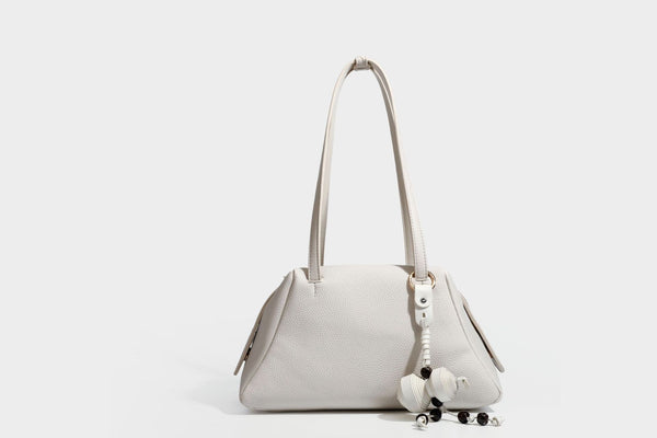 Structured trapezoid shoulder bag in dark brown pebbled leather-look finish with slim double straps, top zip closure, side