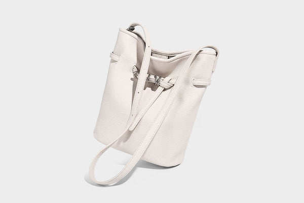Small pebbled leather-look bucket bag with front drawstring toggle hardware and long adjustable shoulder strap, detail view