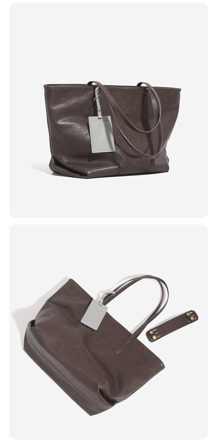 Large leather-look tote bag with trapezoid silhouette, double shoulder straps, and detachable hanging tag, detail view 13