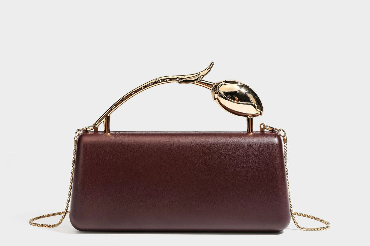Strukturierte rechteckige Clutch mit goldfarbenem Henkel in Form einer Rosenknospe und abnehmbarem Kettenriemen in Metallic-Optik, Detailansicht