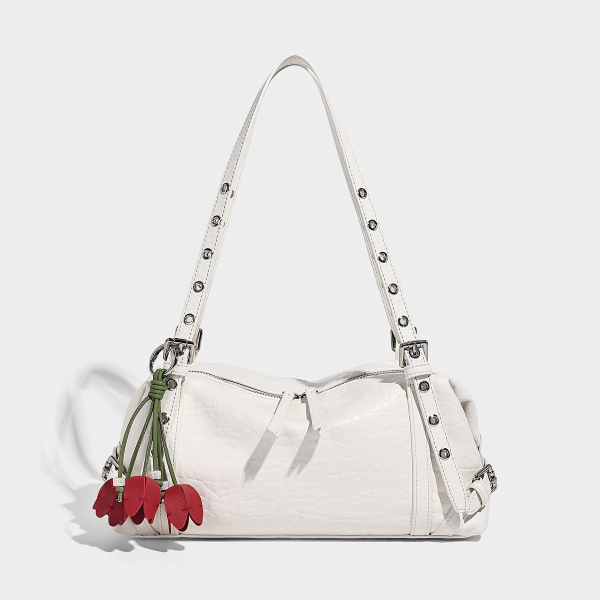 Pale yellow leather-look barrel bag with silver grommet-studded shoulder straps, top zip closure, and pink tulip floral