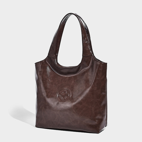 Glossy oil-wax leather-look open-top tote shoulder bag with embossed circular logo and long double straps, detail view 7