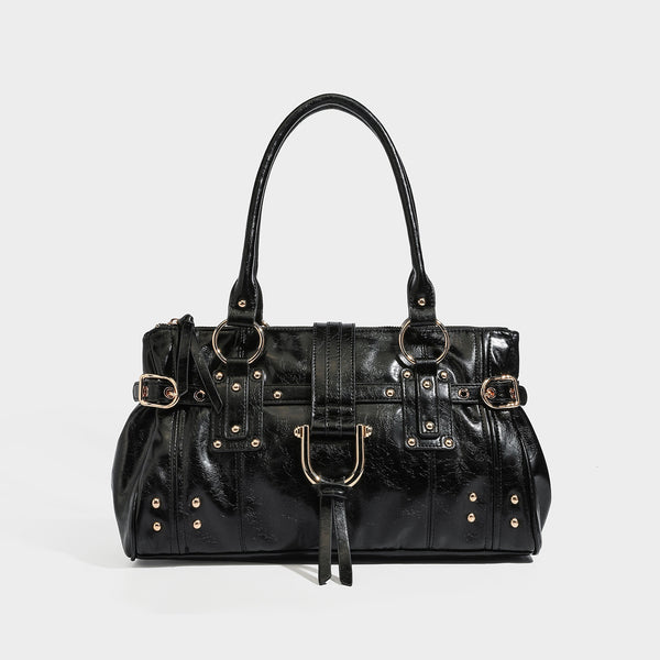 Glänzende Henkeltasche in Lederoptik mit zwei Tragegriffen, goldfarbenen Nieten und Ringen, dekorativem Riemen mit Schnalle auf der Vorderseite und