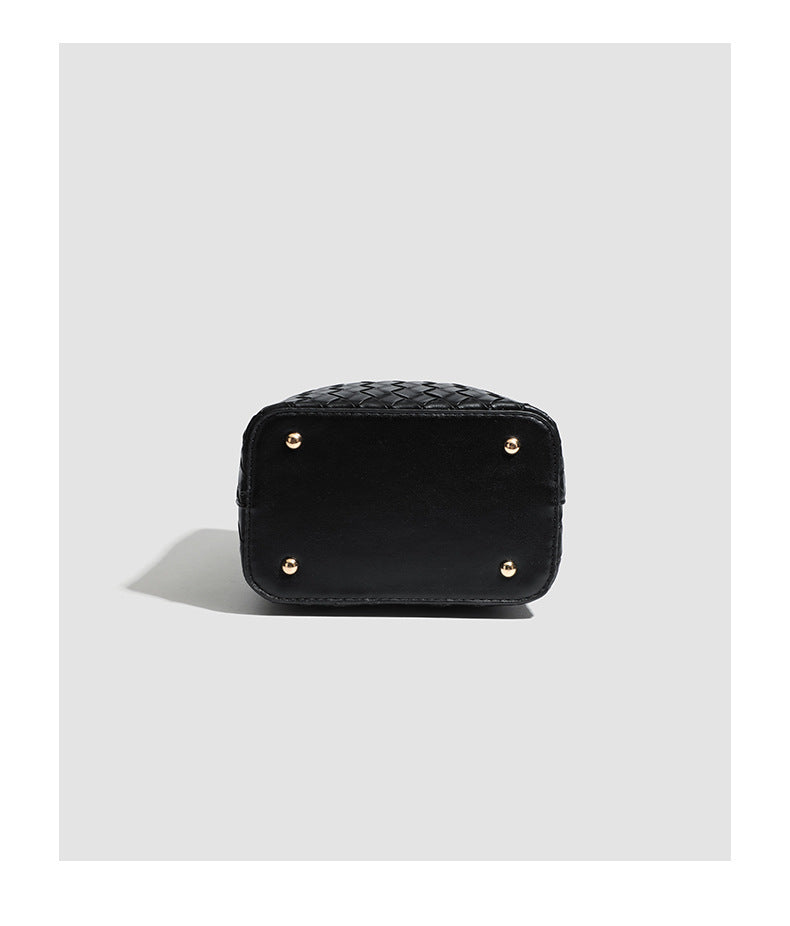 Black woven leather-look bucket bag with gold-tone clip closure, top handle, detachable shoulder strap, and knit bunny charm