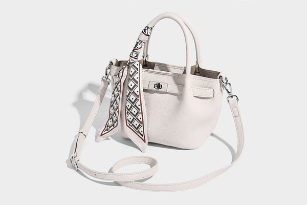 Kleine strukturierte Henkeltasche aus genarbtem Material in Taupe mit zwei Henkeln, bedrucktem Schalband, vorderem Drehverschluss und, Detail