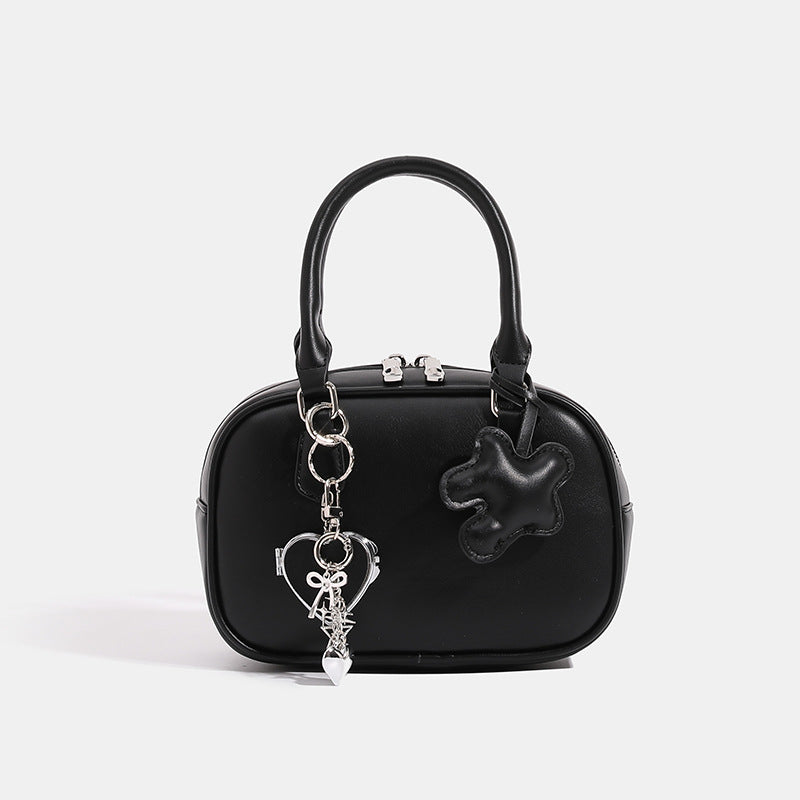 Small structured rounded-rectangle mini handbag with glossy leather-look finish, top zip closure, silver-tone hardware, and