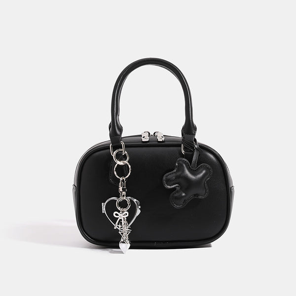 Small structured rounded-rectangle mini handbag with glossy leather-look finish, top zip closure, silver-tone hardware, and
