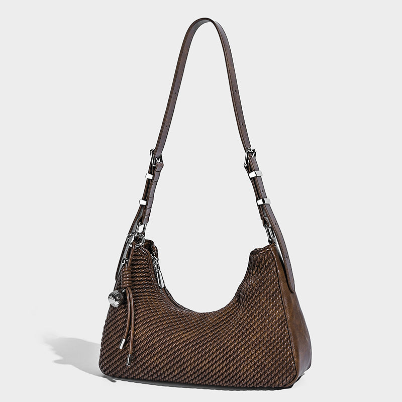 Woven crescent hobo shoulder bag with smooth side panels, zip-top closure, silver-tone charm hardware, and adjustable, front