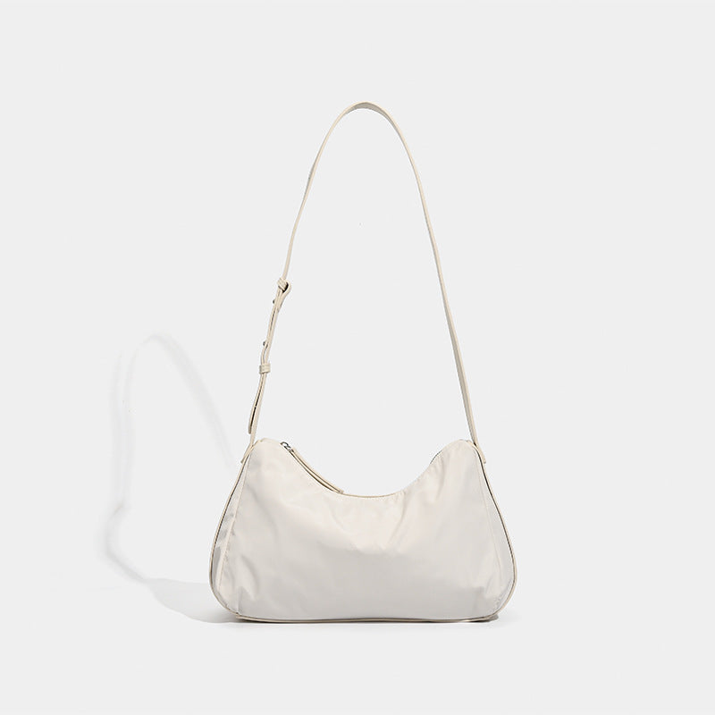 Soft crescent shoulder bag in smooth sheen nylon with contrast leather-look trim, slim adjustable strap, and top zip closure