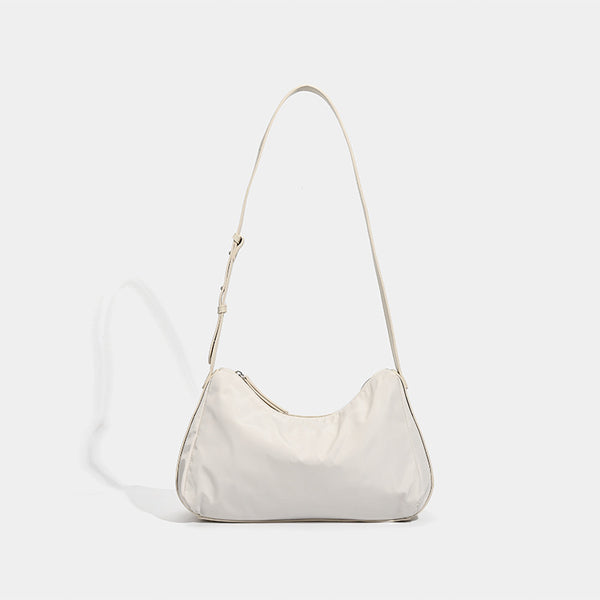 Soft crescent shoulder bag in smooth sheen nylon with contrast leather-look trim, slim adjustable strap, and top zip closure