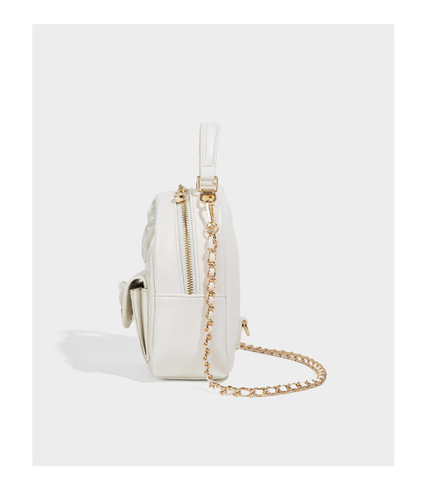Structured mini backpack handbag with butterfly embroidery, gold-tone chain strap, and turn-lock front flap pocket, detail