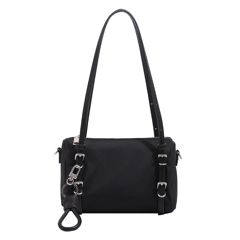 Compact nylon Boston barrel bag with zip-top closure, silver-tone hardware, dual slim handles, and detachable crossbody